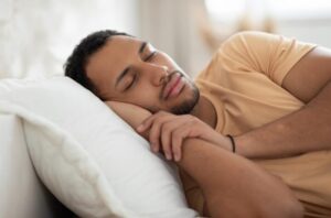 Homem dormindo tranquilamente em uma cama, ilustrando a importância da qualidade do sono.