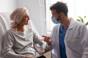 Mulher diagnosticada com leucemia conversando com seu médico a respeito do seu tratamento e qualidade de vida. 