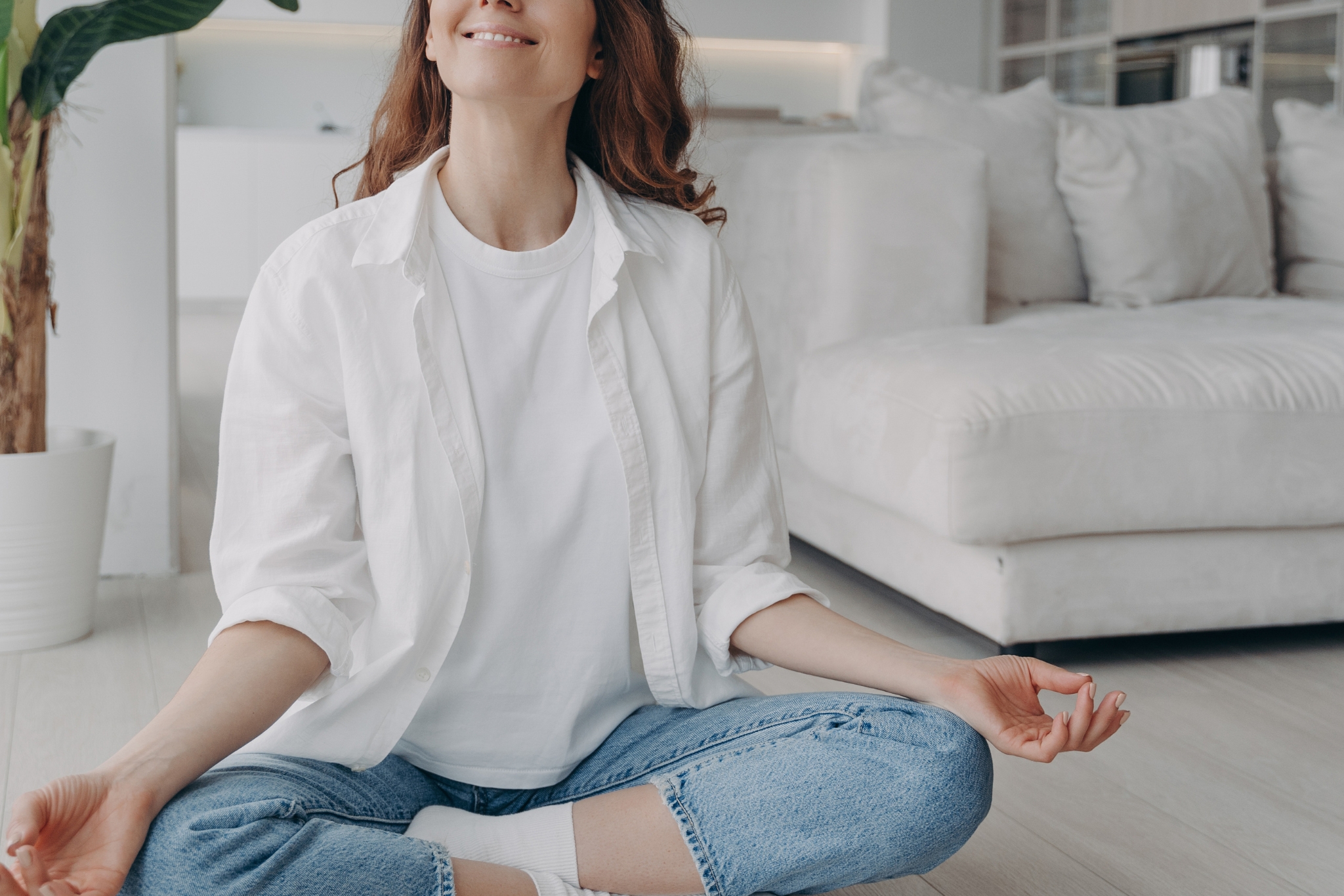 mulher meditando e sorrindo vestida de branco
